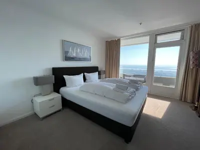 Ein Bett oder Betten in einem Zimmer der Unterkunft Traveblick Ecksuite Queen-Mary Travemünde 30 Etage mit Meerblick am Strand gelegen