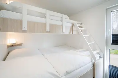 Ein Bett oder Betten in einem Zimmer der Unterkunft Ostseecamp Chalet Haffkrug No 55