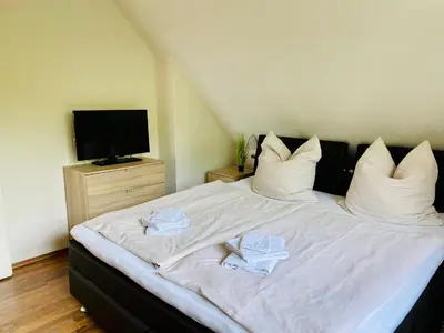 Ein Bett oder Betten in einem Zimmer der Unterkunft FeWo PANORAMADECK Familien-strandnah-Garten-Hunde-Sport-und Schwimmbadnah-HansaPark