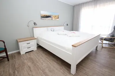 Ein Bett oder Betten in einem Zimmer der Unterkunft Dünenhaus Steuerbord, Fewo 112