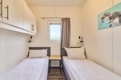 Ein Bett oder Betten in einem Zimmer der Unterkunft Süsel Seeparx Ferienhaus Delphin