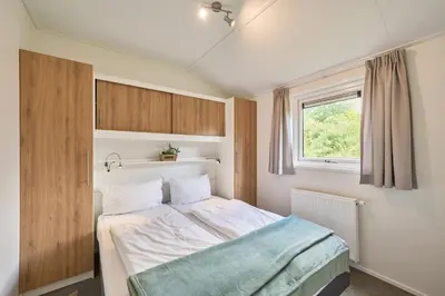 Ein Bett oder Betten in einem Zimmer der Unterkunft Süsel Seeparx Ferienhaus Seeflüstern