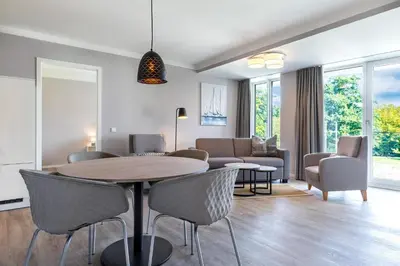 Ein Sitzbereich in der Unterkunft Godewindpark Deluxe-Suite 1-04 mit Gartenblick und Loggia