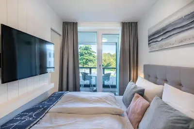 Ein Bett oder Betten in einem Zimmer der Unterkunft Godewindpark Deluxe-Apartment 1-10 mit Gartenblick
