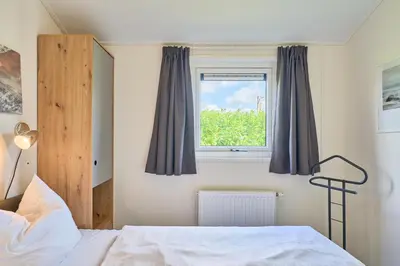 Ein Bett oder Betten in einem Zimmer der Unterkunft Süsel Seeparx Ferienhaus Seewind mit Zaun