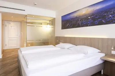 Ein Bett oder Betten in einem Zimmer der Unterkunft Hotel IV Jahreszeiten Lübeck