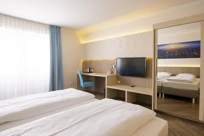Ein Bett oder Betten in einem Zimmer der Unterkunft Hotel IV Jahreszeiten Lübeck