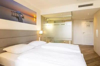 Ein Bett oder Betten in einem Zimmer der Unterkunft Hotel IV Jahreszeiten Lübeck