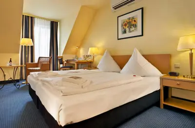 Ein Bett oder Betten in einem Zimmer der Unterkunft Tryp by Wyndham Luebeck Aquamarin